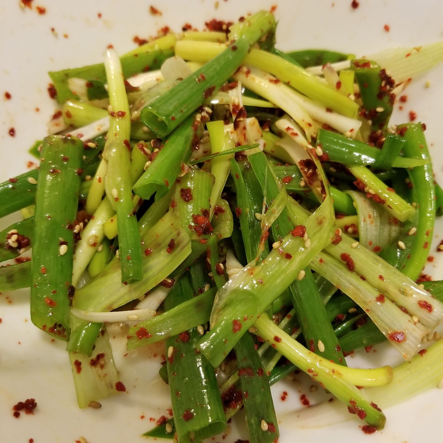 Spicy Leak Salad - Instructional image for cutting green leeks in Korean cooking style.